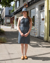 Load image into Gallery viewer, Old Fashion Standards button skirt and 6 panel hat in formal ticking styled with filippa k halter printed swimsuit in blue print and no.6 contour clog in tobacco - front
