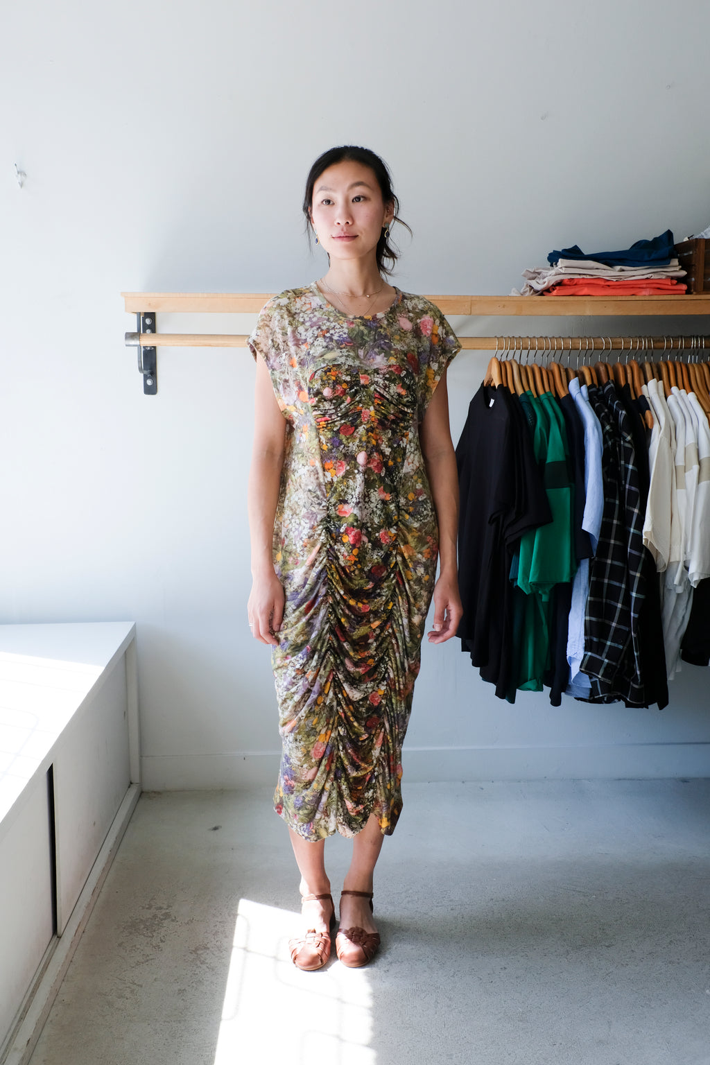 Anntian - Linen Dress - Print D - Front. Beautiful linen dress with inverted fabric on the side panels. The print is a photograph of vibrant florals featuring yellows, pinks, fuchsia, light blues and deep greens. This print appears more muted on the inverted panels and cleverly guides the viewer’s eyes through luxurious ruching to the centre of the body. It is flattering on the figure but retains a relaxed fit. 
