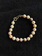 Monica Berdin - Freshwater pearl bracelet with brass clasp on a black background