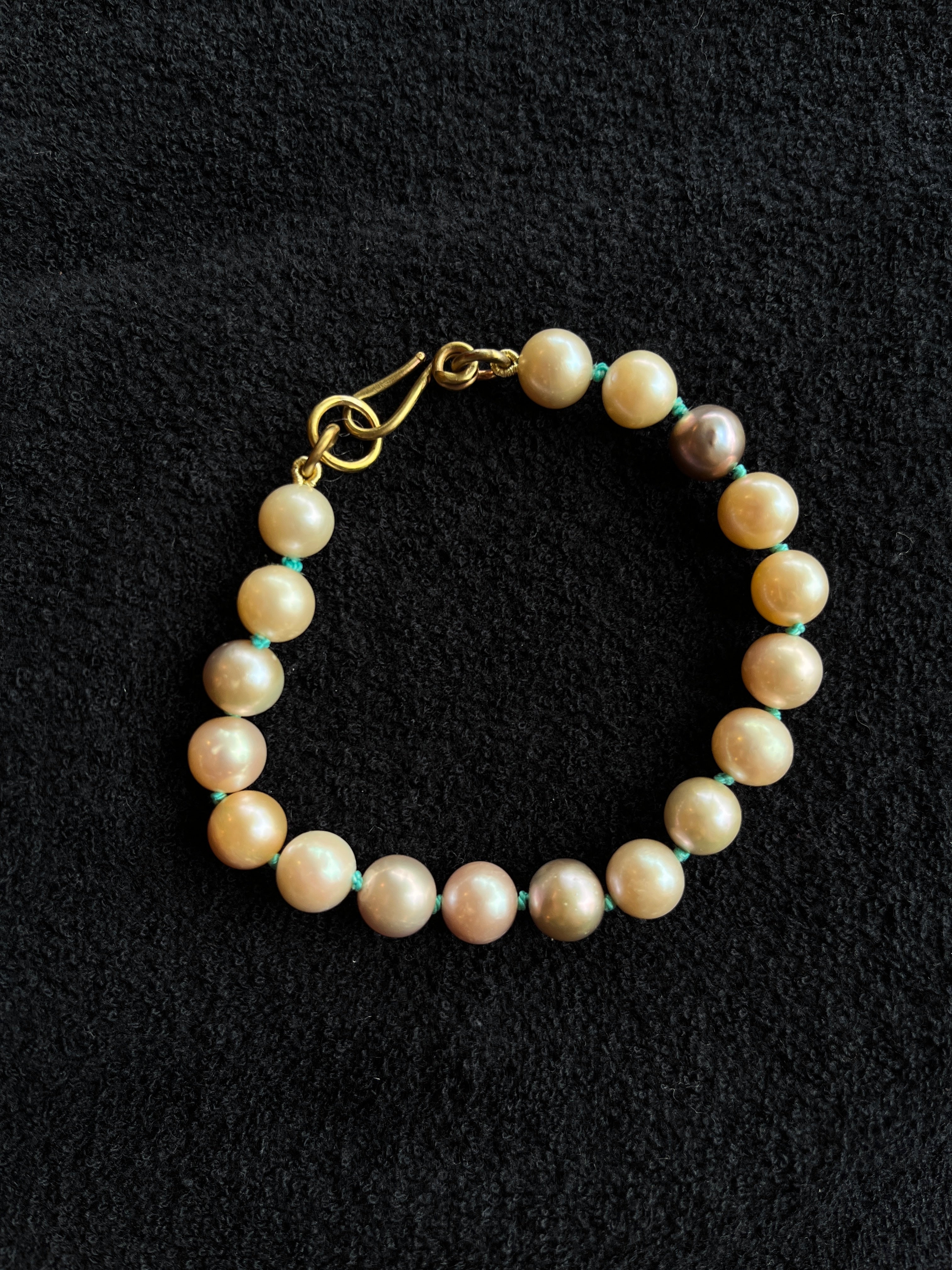 Monica Berdin - Freshwater pearl bracelet with brass clasp on a black background