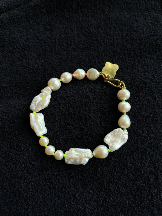 Monica Berdin - Freshwater pearl bracelet with brass clasp on a black background