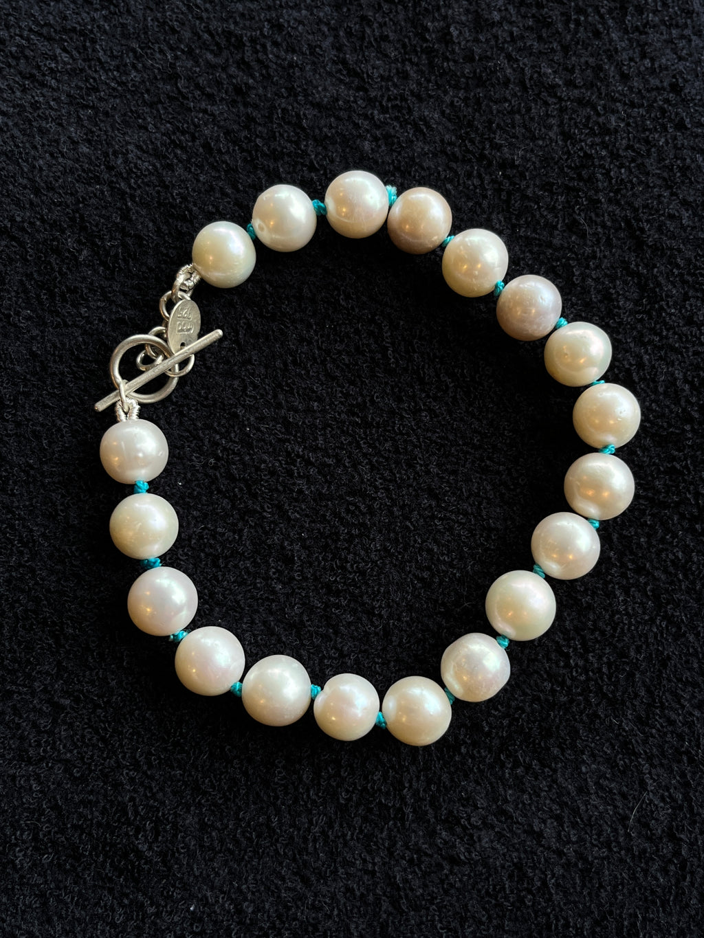 Monica Berdin - Freshwater pearl bracelet with sterling silver clasp on a black background