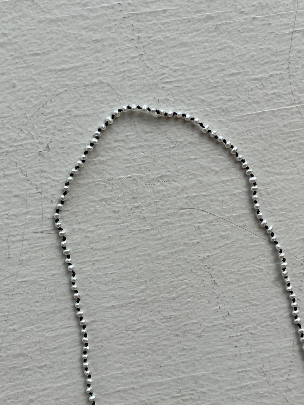 Monica Berdin - Mini pearls necklace on black silk necklace closeup