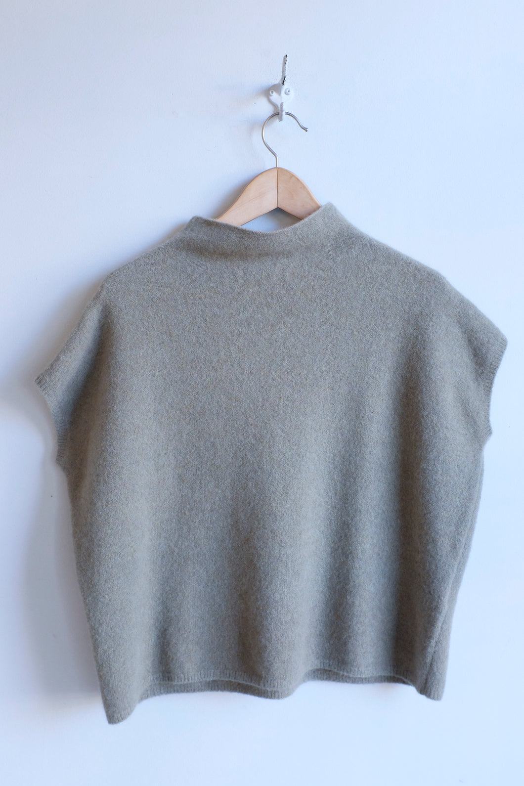 this photograph depicts the front of the sweater. it is a boxy fit with hung sleeves.