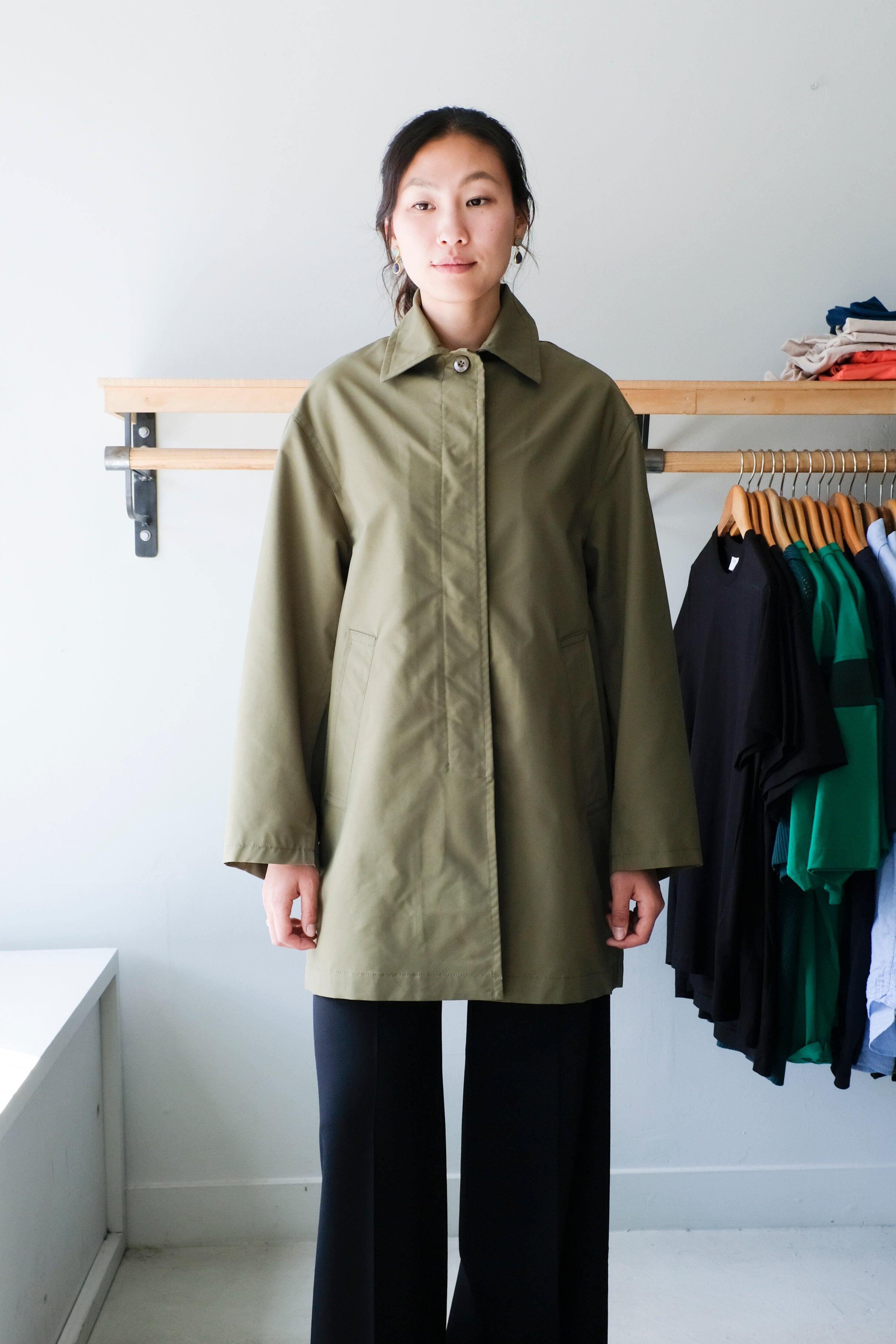 Filippa K - Cassie Car Coat - Laurel Green - Front. This structured thigh length spring-summer coat features a visible button at the top. 