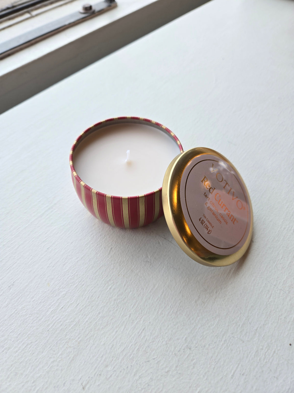 Votivo Red Currant Candle - Travel Tin, with lid open, wick and wax inside