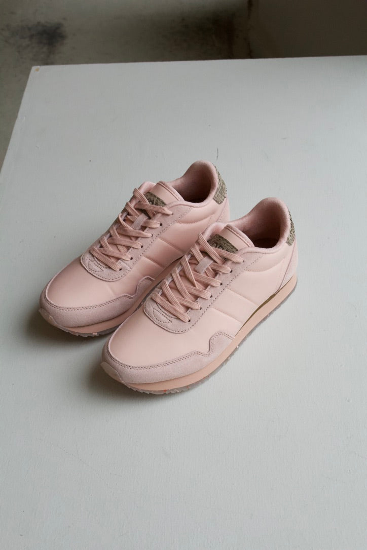 Woden Nora III sneaker in Rose Bloom, a classic baby pink with a soft supple hue. Designed with a rounded toe and beige faux snake skin details on the top of the heel. 