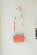 Load image into Gallery viewer, The demi-lune mini bag in Coral - this signature leather bag from APC is a true coral colour, a soft pink hue with hints of orange
