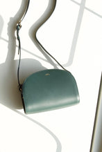 Load image into Gallery viewer, A.P.C Demi-Lune Bag in Vert Sapin - Eugene Choo - Women&#39;s Accessories: this classic purse has a sophisticated design and features a deep forest green colour that will darken and intensify as it ages. 
