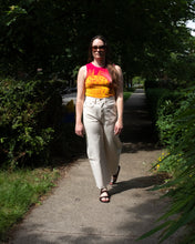 Load image into Gallery viewer, Jamie strutting down a very green sidewalk with dramatic lighting in B-sides lasso jean styled with Paloma Wool The Gate Tank and Jerusalem Sandals Golan - front
