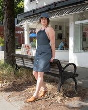 Load image into Gallery viewer, Jamie is leaning on a bench in front of Liberty cafe on Vancouver&#39;s Main Street on a hot summer day in the matching Old fashion Standards button skirt and 6 panel cap in formal ticking, Filippa K Halter printed swimsuit in blue print and no.6&#39;s contour clog in tobacco for a cute blue-brown outfit. The swimsuit and skirt&#39;s textures and patterns contrast each other perfectly in a subtle way.
