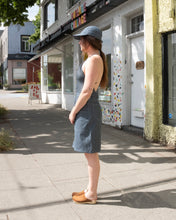 Load image into Gallery viewer, Old Fashion Standards button skirt and 6 panel hat in formal ticking styled with filippa k halter printed swimsuit in blue print and no.6 contour clog in tobacco - side
