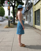 Load image into Gallery viewer, Old fashion standards button skirt and 6 panel cap in light denim styled with filippa k halter printed swimsuit in beige stripe paired with no.6 contour clog in tobacco - side
