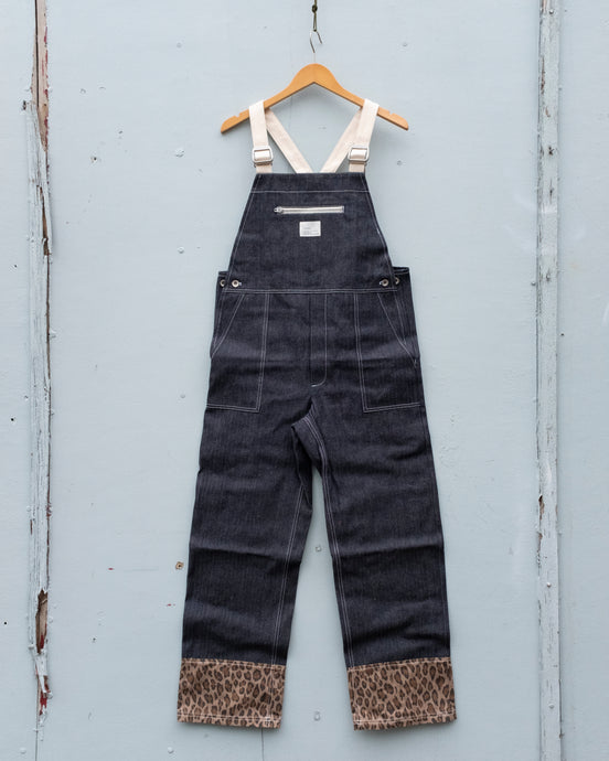 W'menswear Holiday Dungaree features a leopard print fabric at the end of its legs, well contrasted to its overall dark denim fabric and off-white detailing. The brass hardware adds an extra bit of warmth! It has got a front chest pocket that can be zipped up, and two hip pockets in the front.